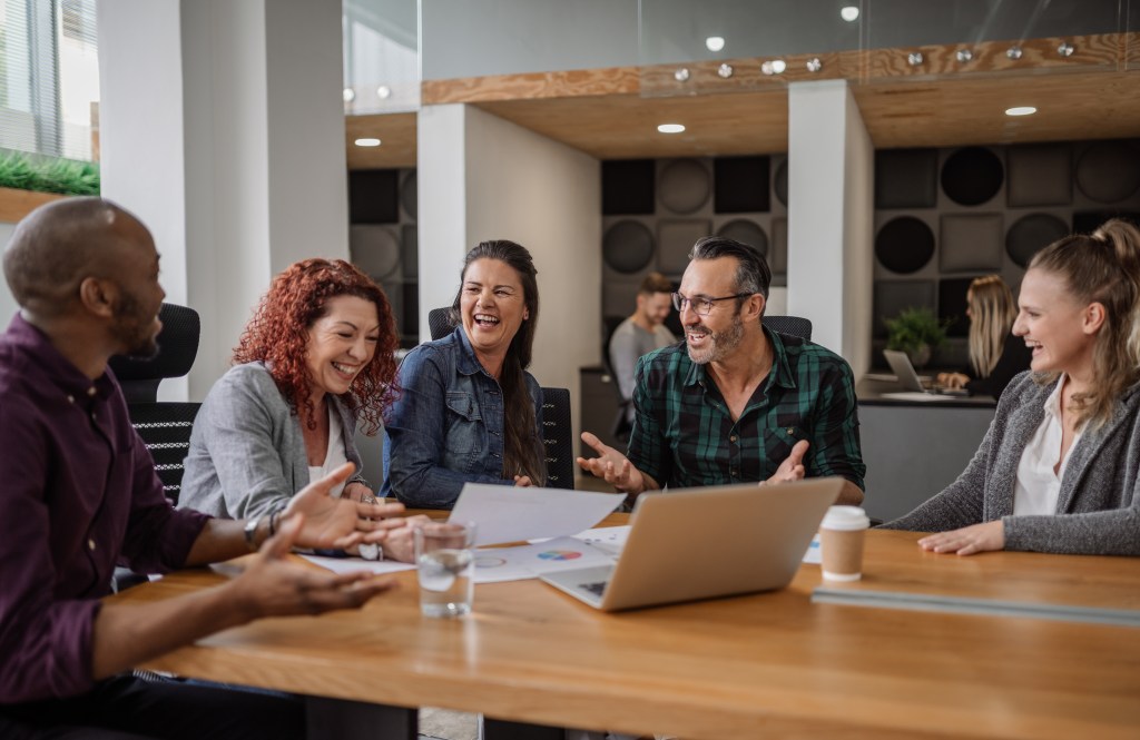 A group meets at a library while looking over a presentation.