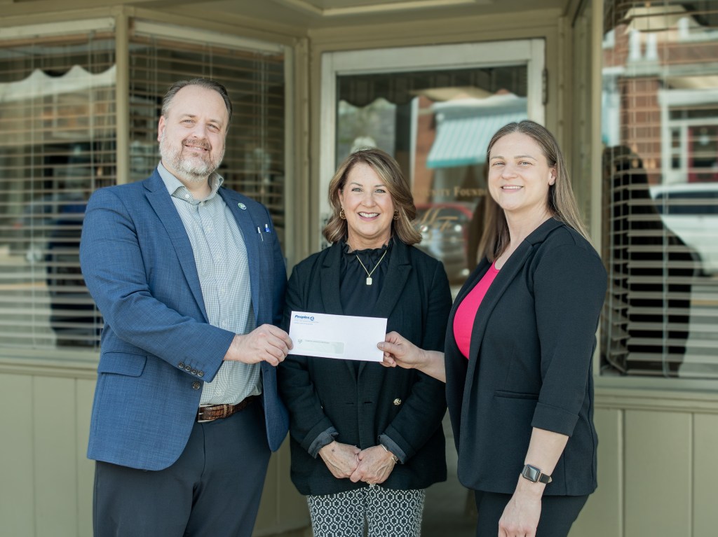 Peoples Bank CEO Tyler Wilcox and Peoples Insurance President Staci Matheny present a check to the Marietta Community Foundation.