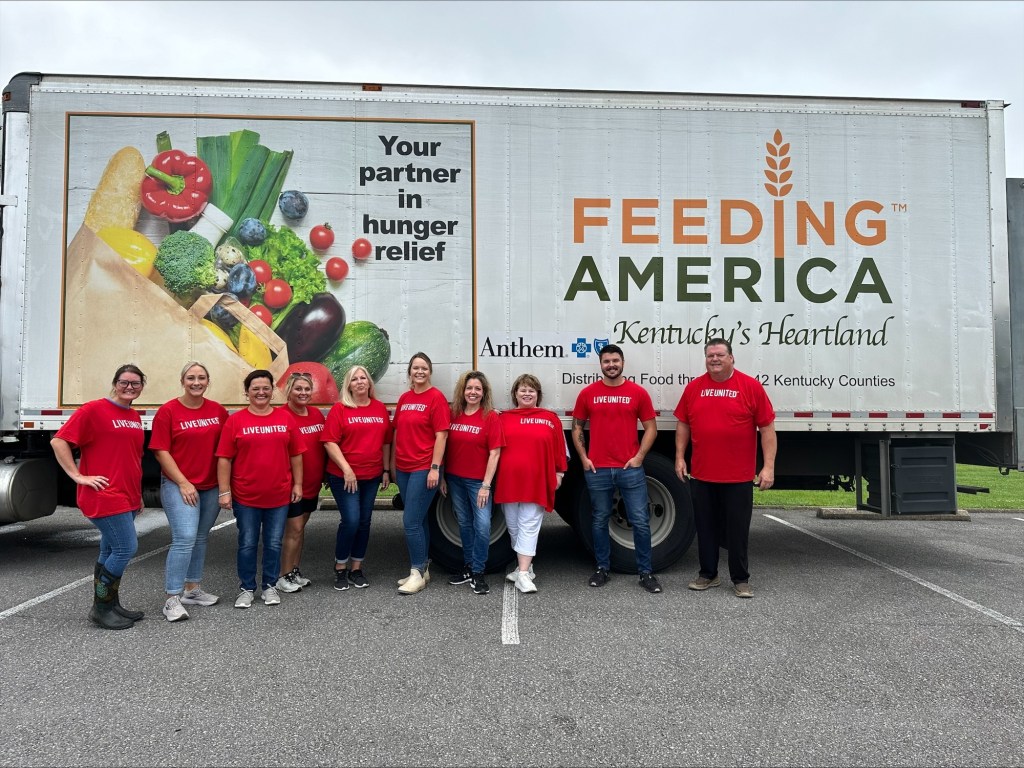 Peoples Bank employees stand in front of the Feeding America food truck.