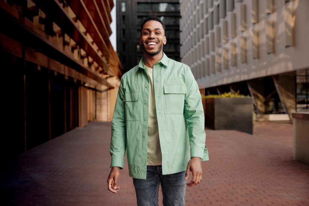 A male walks down an urban street.