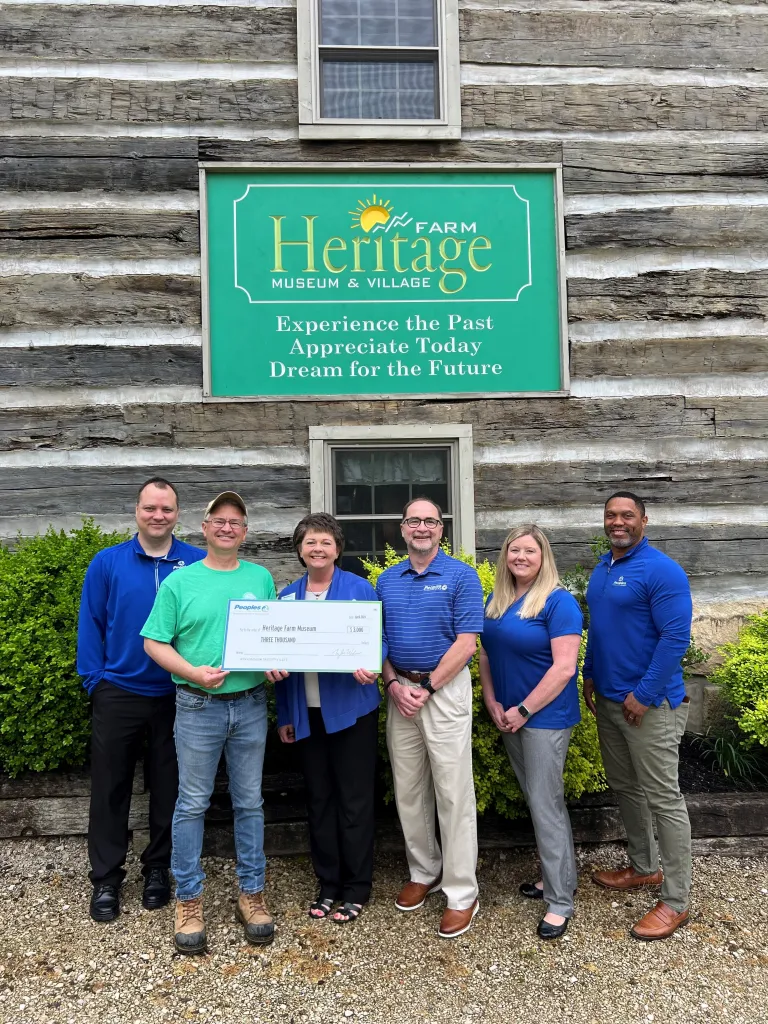 Four Peoples Bank associates present a check to the Heritage Farm Museum in Huntington, WV.
