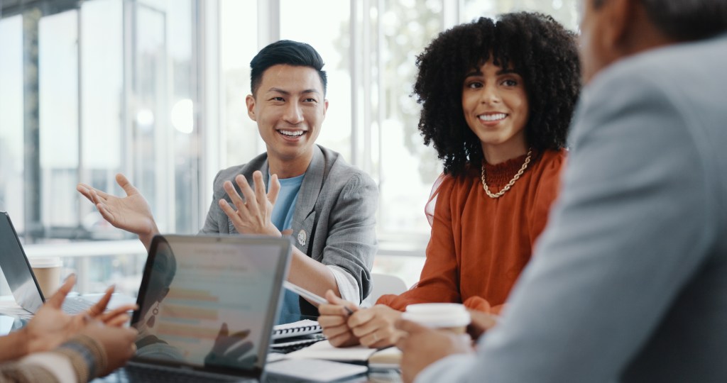 Four people planning a project together in the office conference room.