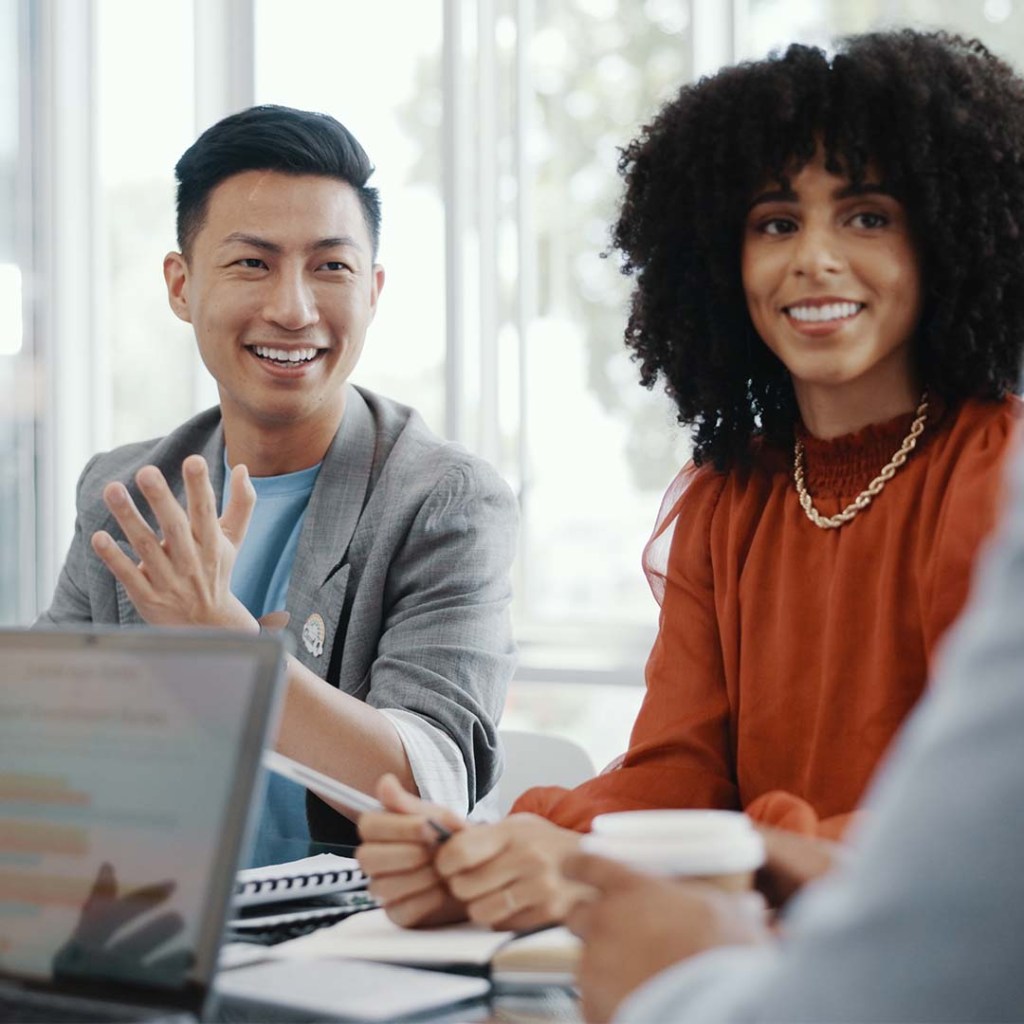 Four people having a team planning meeting together in the office conference room. 