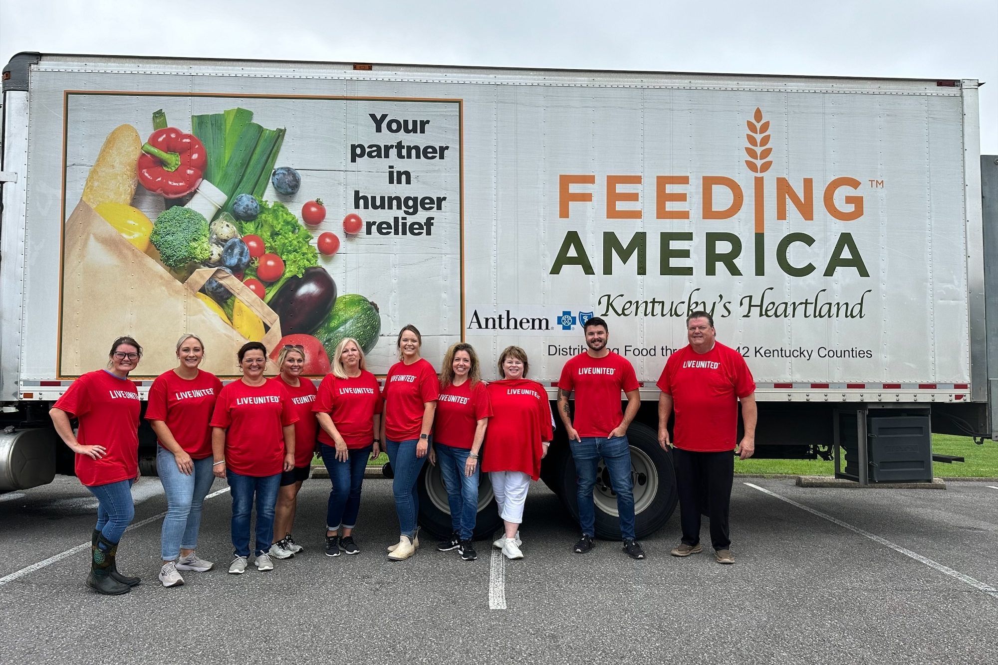 Peoples Bank employees stand in front of the Feeding America food truck.