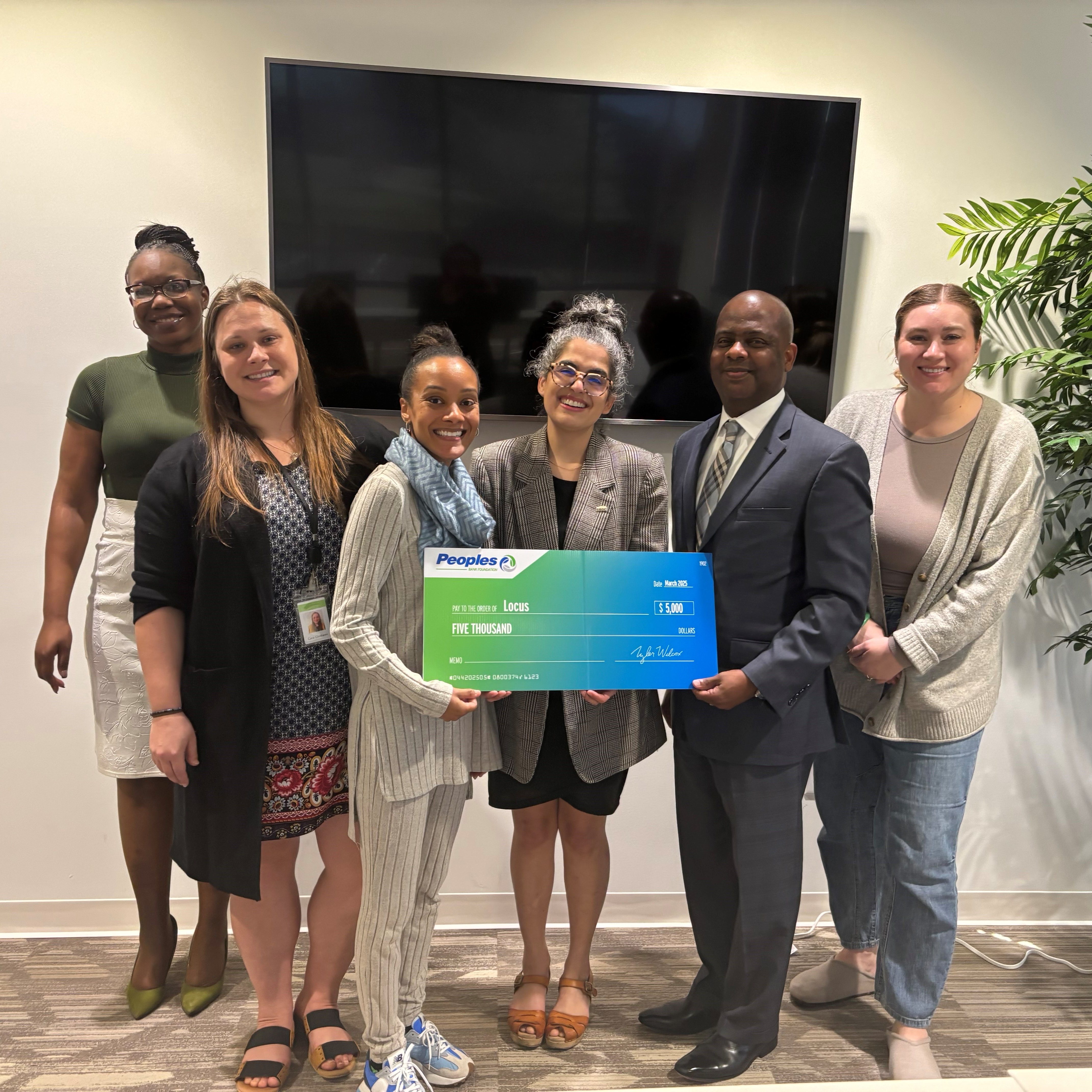 Peoples Bank associates present a check to Locus in Richmond, Virginia.