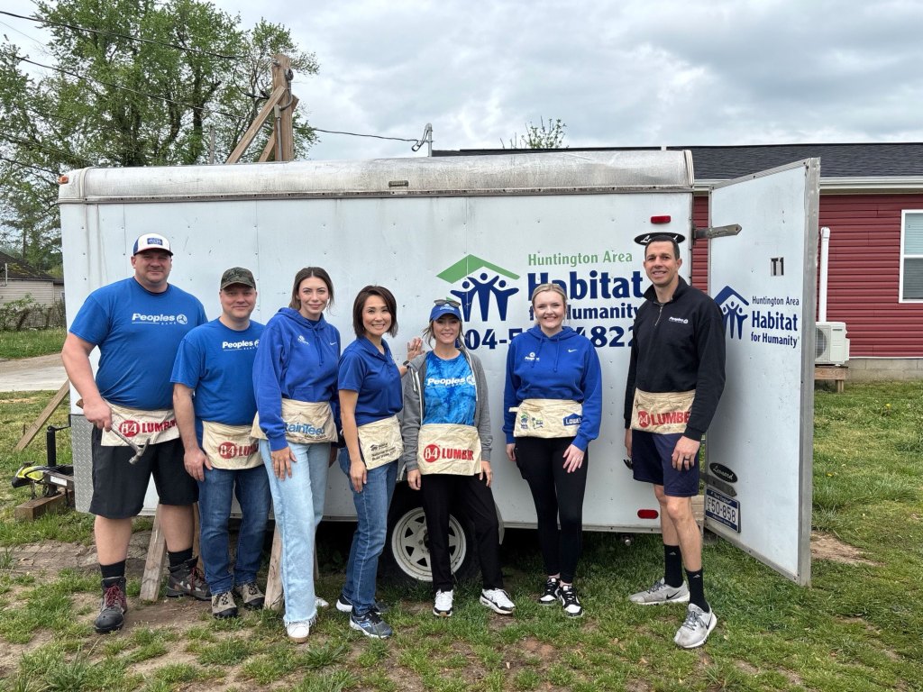 Peoples Bank associates pose in front of the Habitat for Humanity supply trailer.