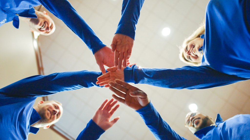 Six Peoples Bank associates put one arm in for a team break.