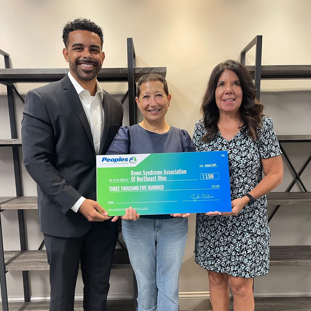 Two Peoples Bank associates stand with a worker of the Down Syndrome Association of Northeast Ohio to present a donation to the organization.