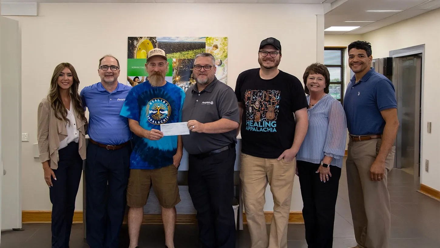Peoples Bank associates present a check to Healing Appalachia members in the Ashland, KY, branch lobby.