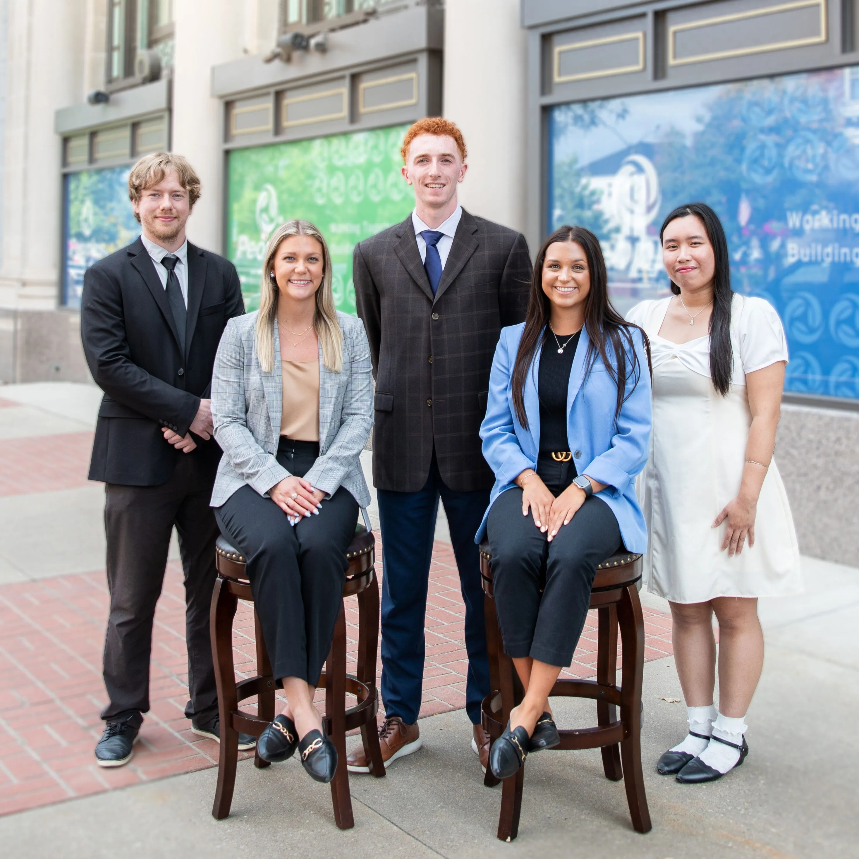 Five Peoples Bank Professional Development Associates stand in front of the Peoples Bank headquarters.
