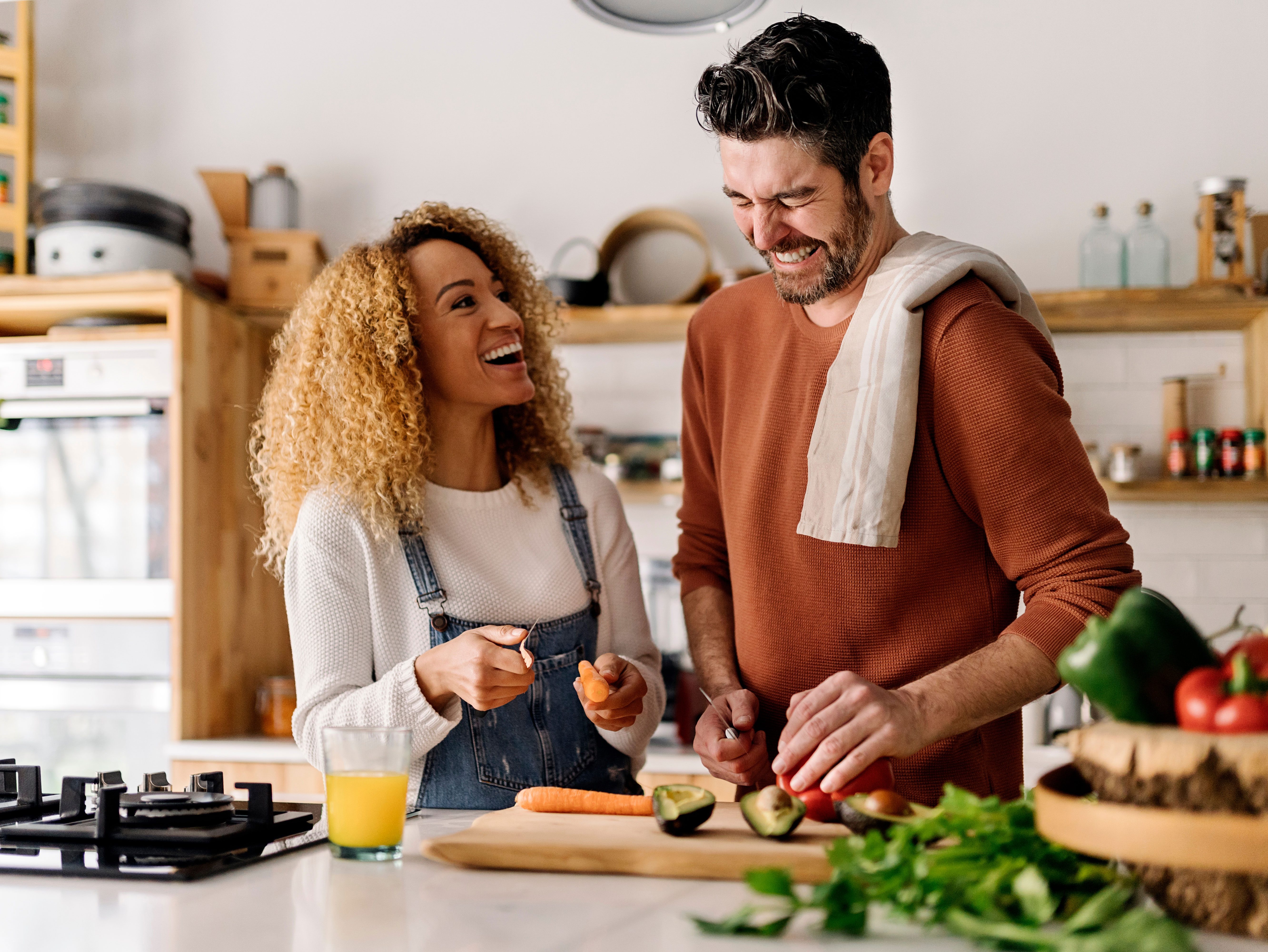 A couple cooks breakfast together in their kitchen.