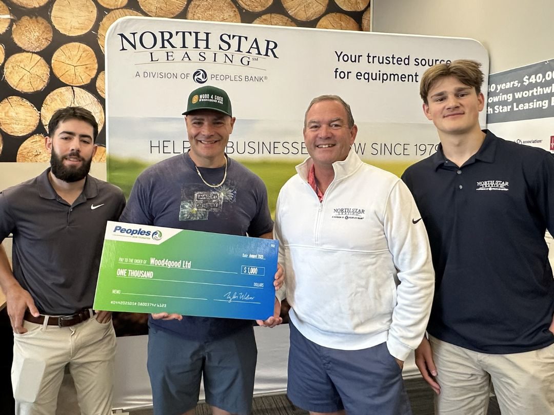 Two Vantage Financial associates (right) present a check to two Wood4Good workers (left). 