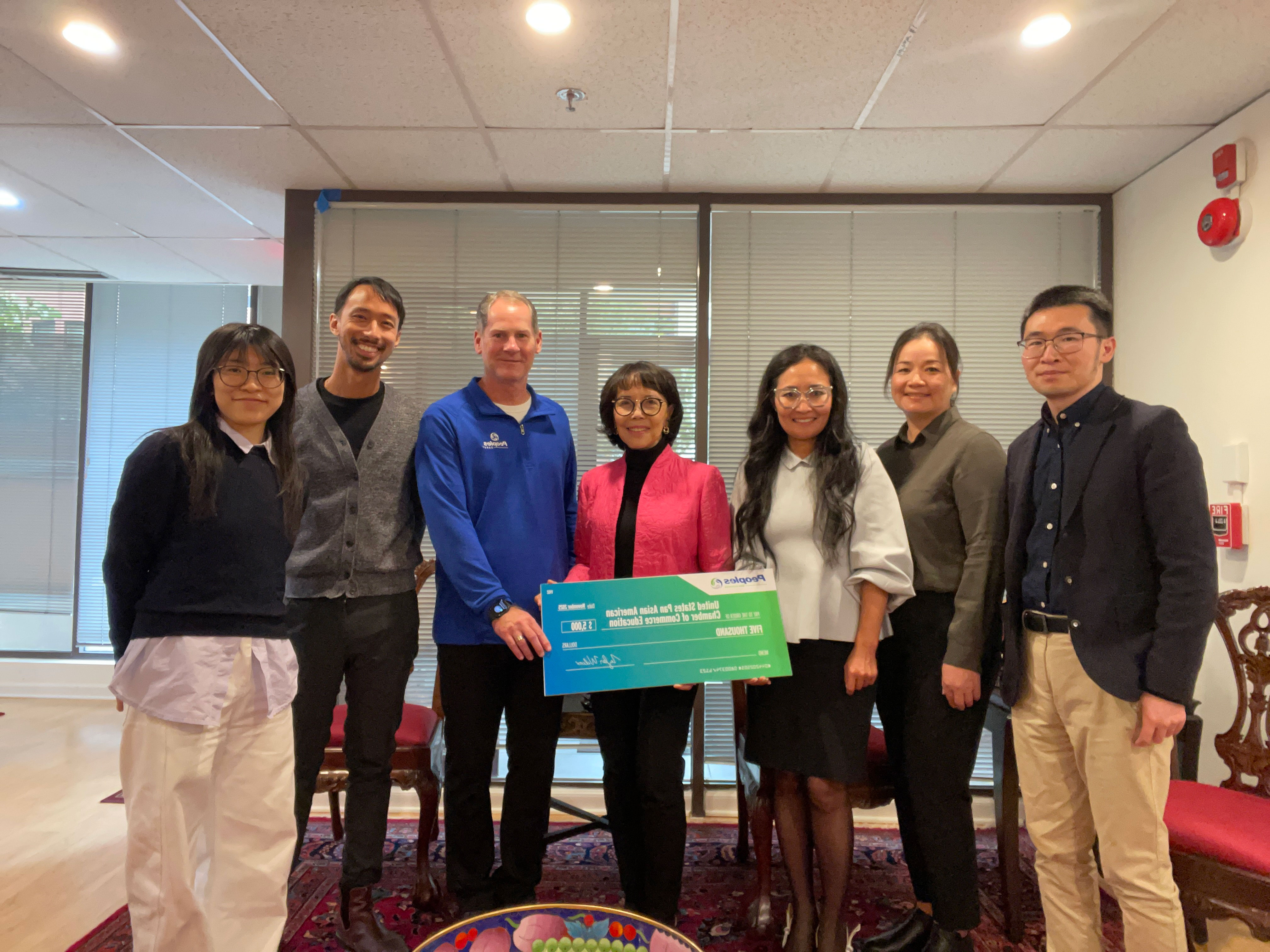 Two Peoples Bank associates present a check donation to five members of the USPAAC in Washington D.C.