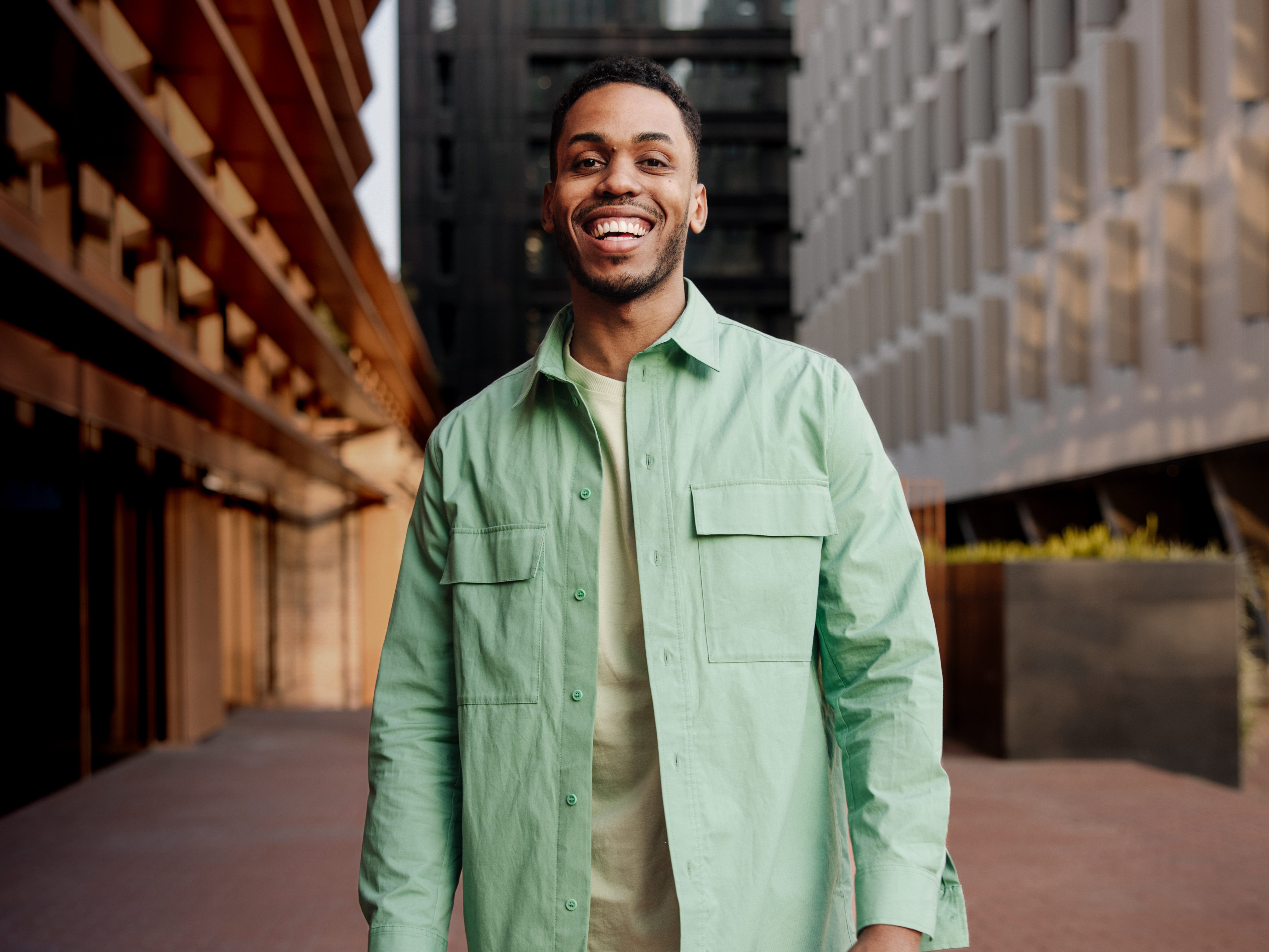 A male walks down an urban street.