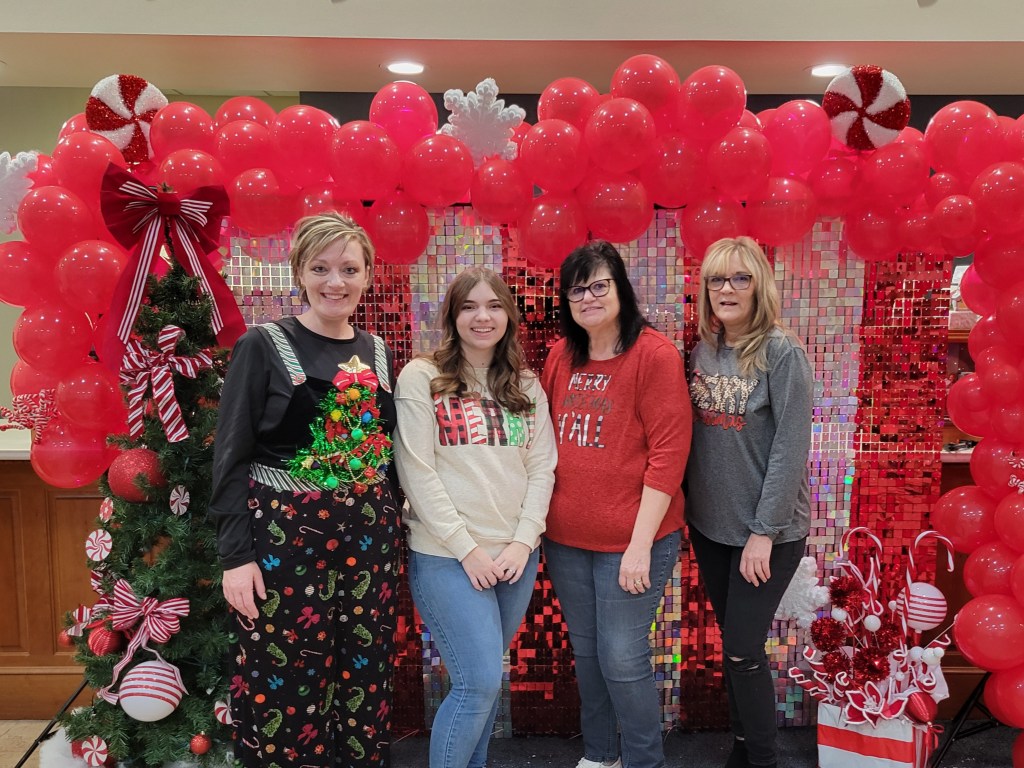 Four Peoples Bank associates stand in front of a holiday backdrop at the Cambridge, OH, branch.