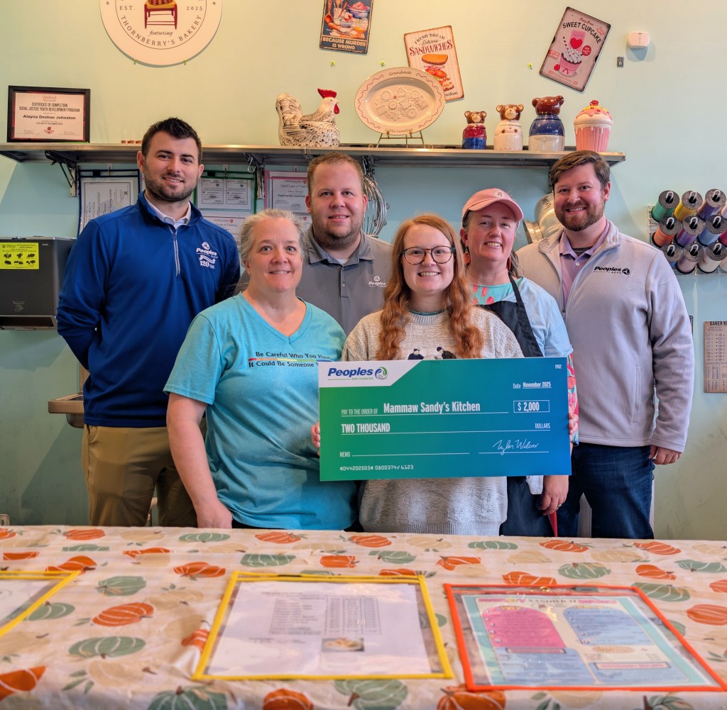 Three Peoples Bank associates present a monetary donation to three associates from Mammaw Sandy's Kitchen in Louisville, KY.
