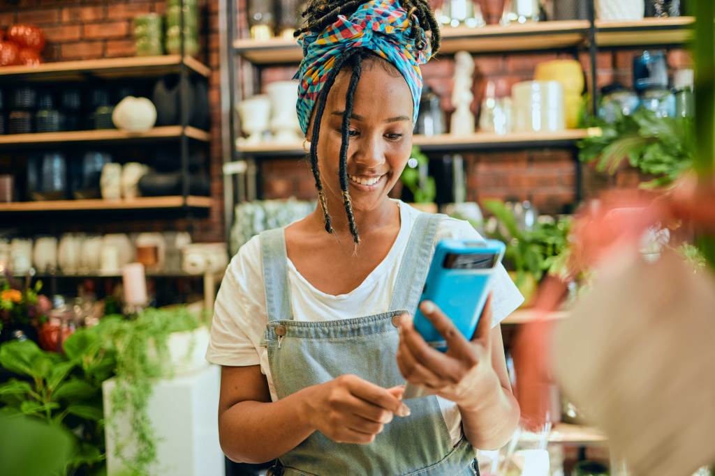 A florists makes a sale by using a credit card and point of sale terminal.