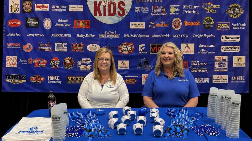 Two Peoples Bank associates sit at a booth at the Casting for Kids event in Paintsville, Kentucky.