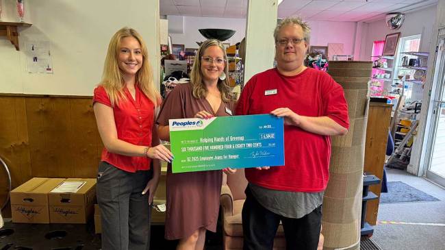 Three Peoples Bank associates present a $6,504 check to the Helping Hands of Greenup in Kentucky.
