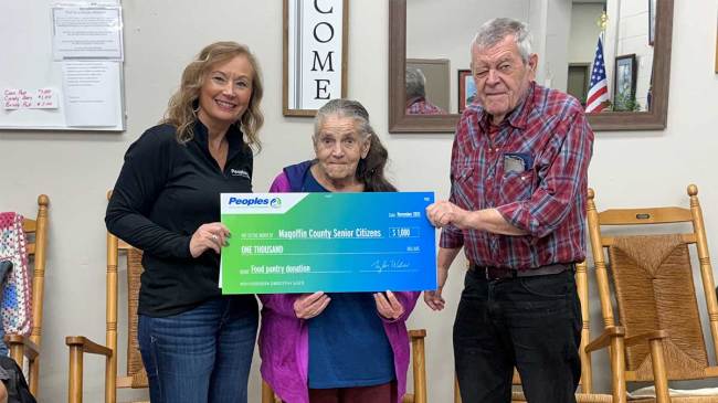 A Peoples Bank associate presents a $1,000 check to two seniors of the Magoffin County Senior Citizens group in Kentucky.