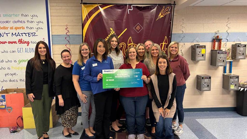 Five Peoples Bank associates present a $1,000 check to the Russell McDowell Intermediate School PTO in Russell, Kentucky.
