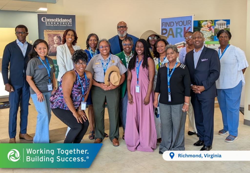 Fifteen attendees, leaders and volunteers from the Maggie Walker Womens Symposium pose for a photo in the Peoples Bank Richmond, Virginia, office.