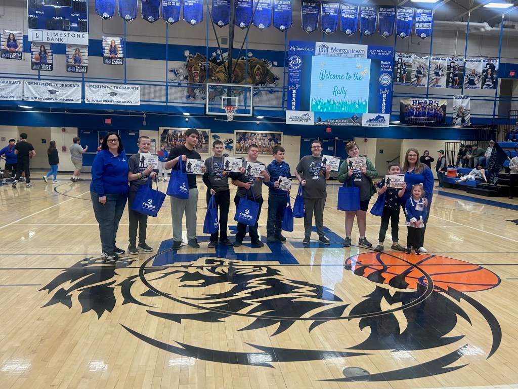 Nine students stand with two People Bank associates to celebrate a Peoples Bank donation to the Special Olympics Basketball team in Butler, County, Kentucky.