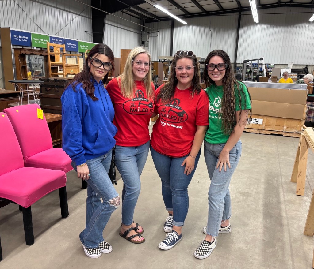 Four Peoples Bank associates stand in the middle of the Habitat for Humanity warehouse in Huntington, WV, for the organization's She Nailed It event.