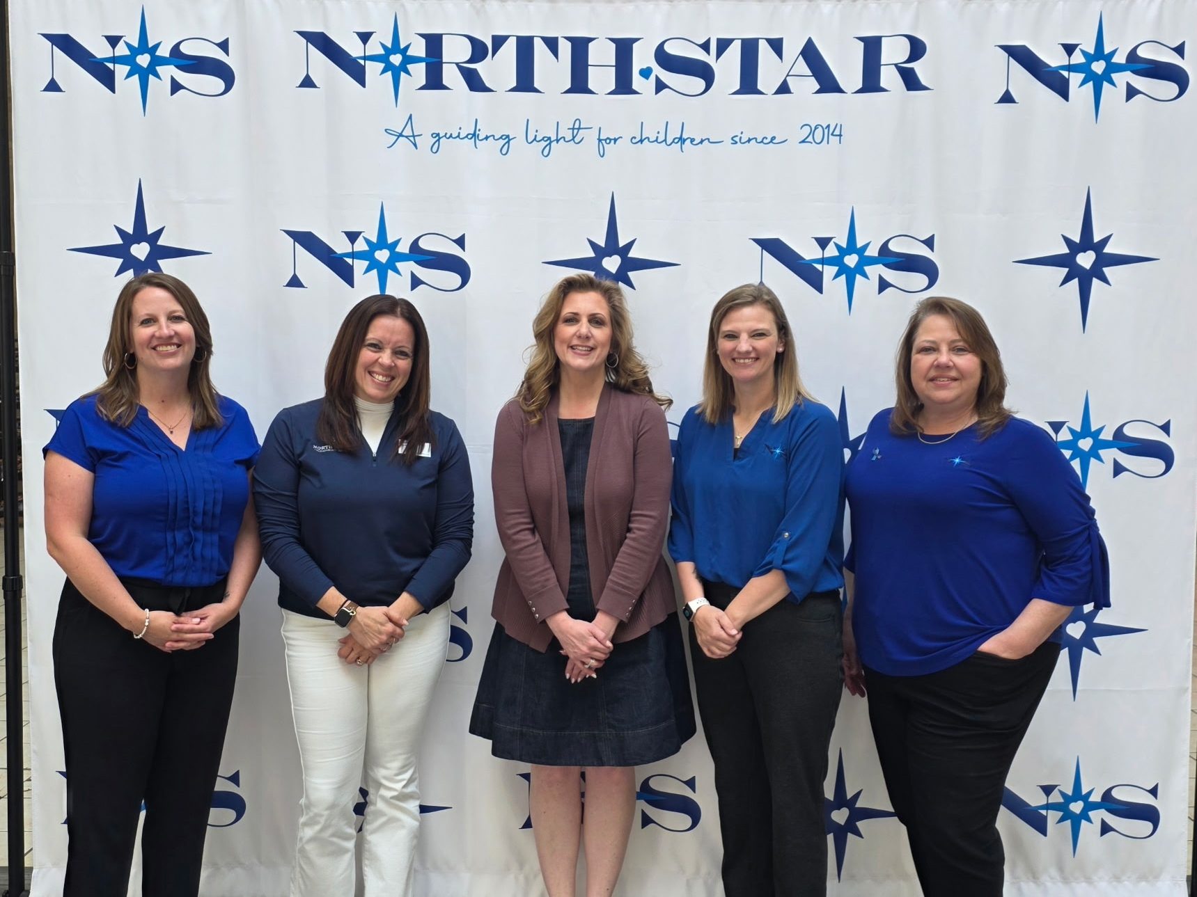 A Peoples Bank associate stands with four North Star Child Advocacy employees for a photo.