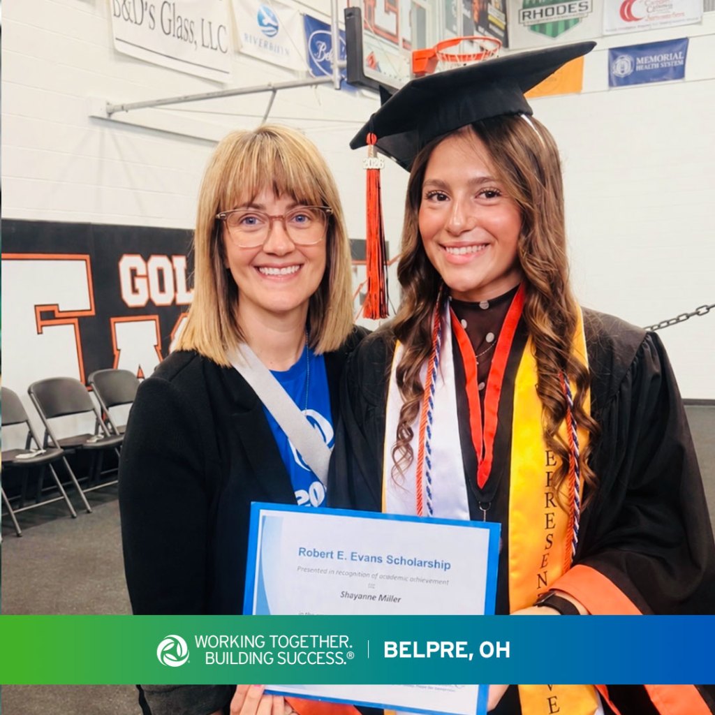 A high school student from Belpre, Ohio, stands with a Peoples Bank associate in a school gymnasium for the Robert Evans Scholarship presentation.
