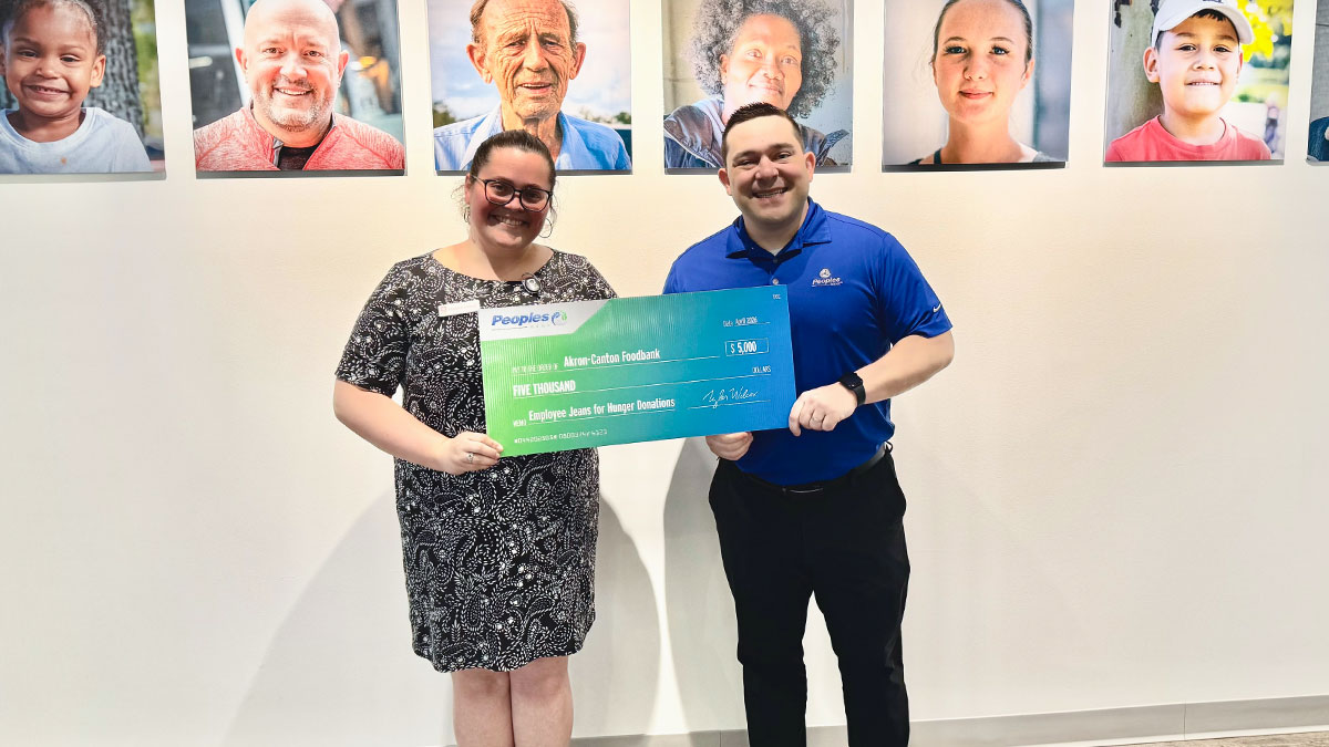A Peoples Bank associate presents a check to the Akron-Canton Foodbank in Ohio.