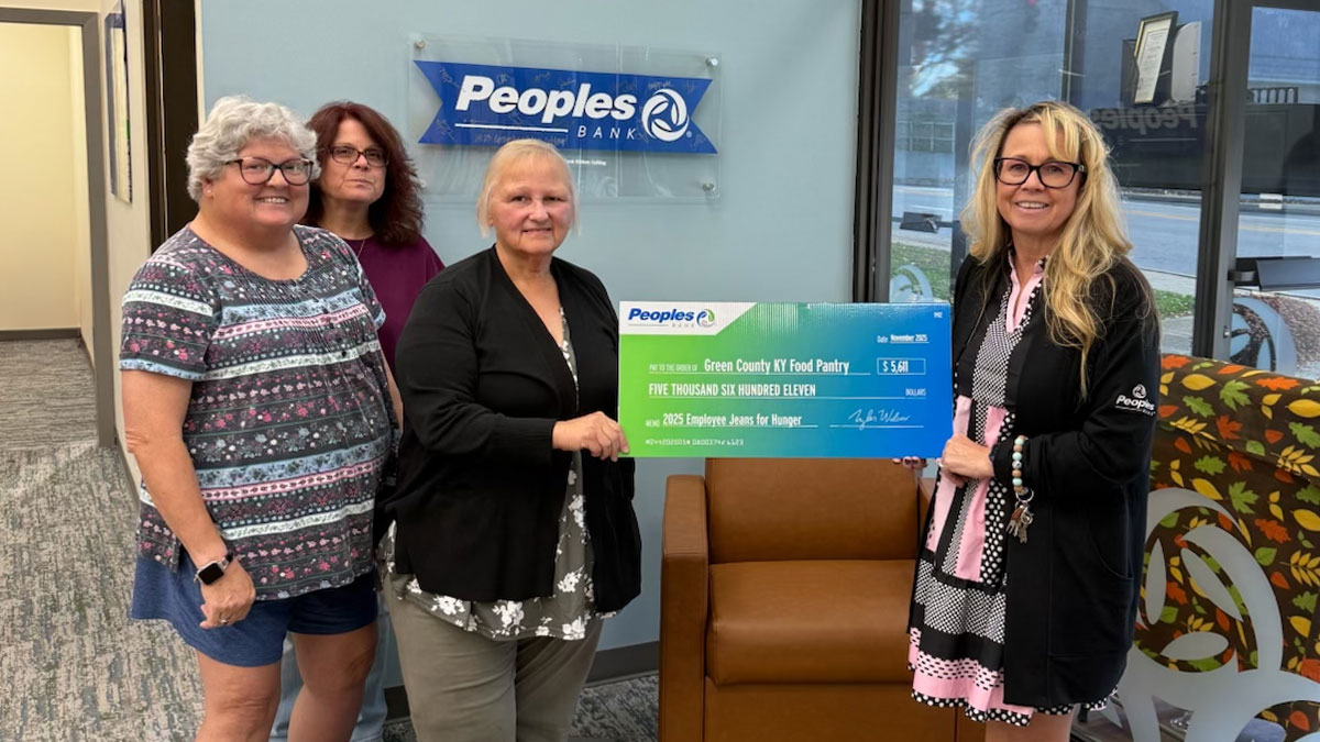 A Peoples Bank associate presents a check to the Green County Food Pantry in Kentucky.