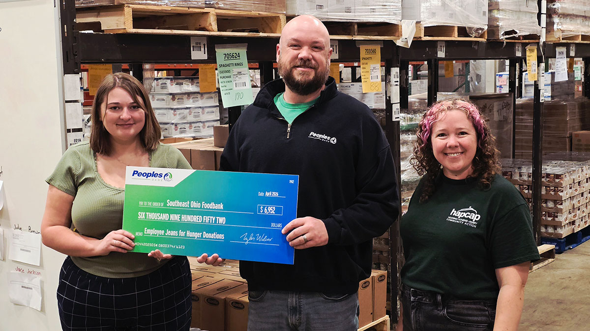 A Peoples Bank associate presents a check to the Southeast Ohio Foodbank.